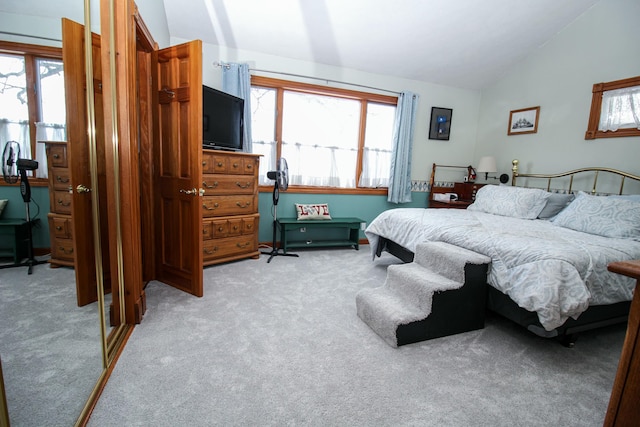 carpeted bedroom with multiple windows and lofted ceiling