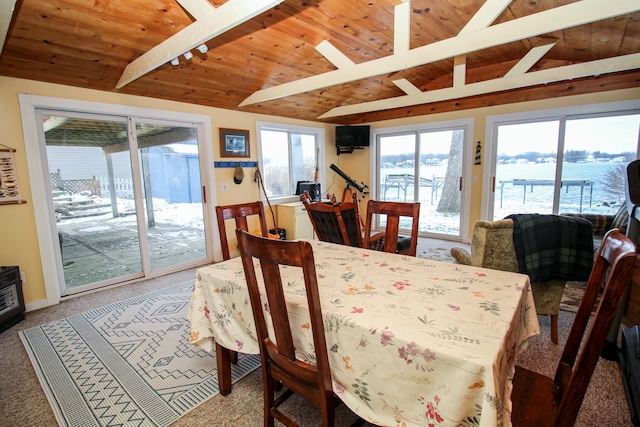 carpeted dining area with vaulted ceiling with beams and wooden ceiling