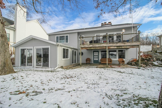 snow covered house with a deck