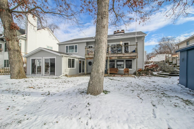 view of snow covered back of property