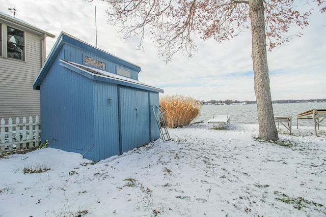 snow covered structure featuring a water view