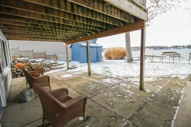 snow covered patio with a shed