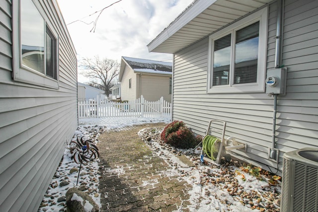 snow covered property featuring central AC unit