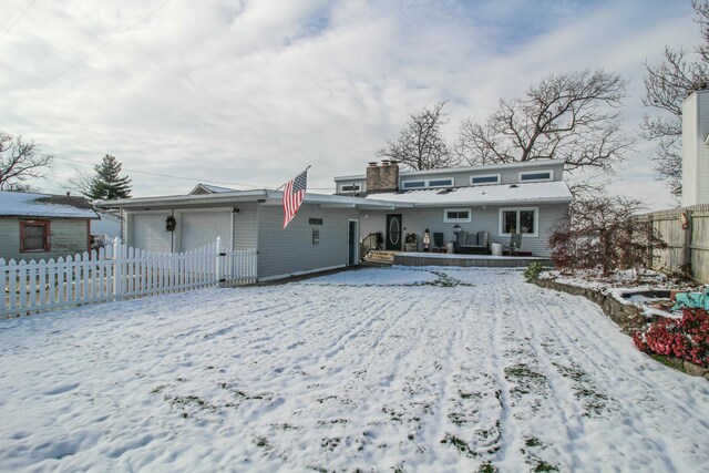 snow covered property with a garage