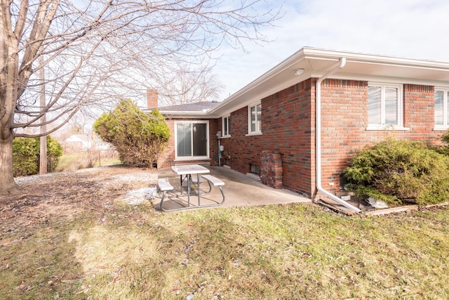 back of house with a lawn and a patio