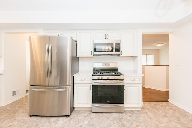 kitchen featuring white cabinetry, light stone countertops, and appliances with stainless steel finishes