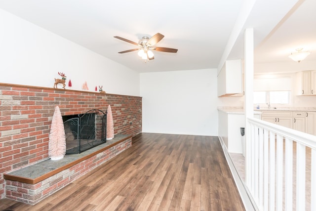 unfurnished living room with ceiling fan, a fireplace, and dark hardwood / wood-style floors