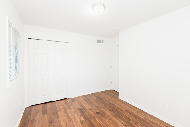 unfurnished bedroom with a closet and hardwood / wood-style floors