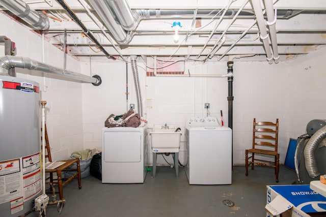 basement featuring water heater, sink, and independent washer and dryer