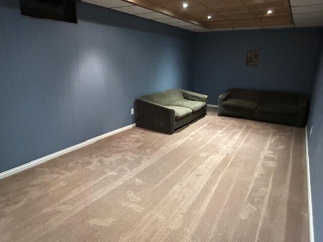 unfurnished room with carpet floors and a drop ceiling