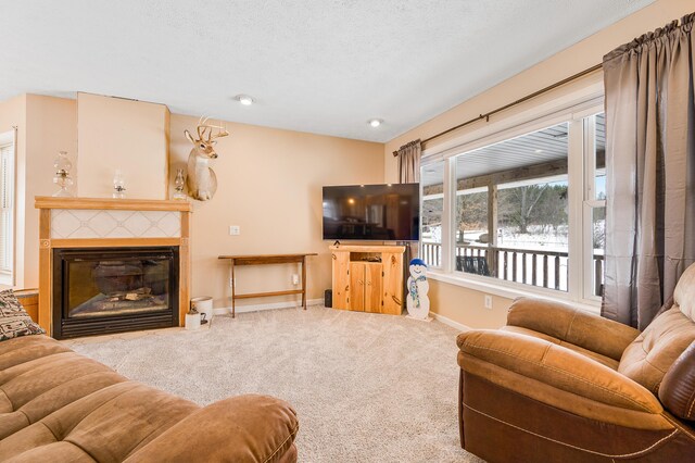 carpeted living room with a tiled fireplace and a textured ceiling