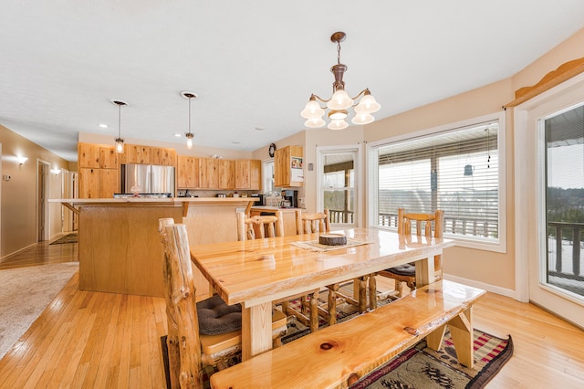 dining room with a notable chandelier and light wood-type flooring