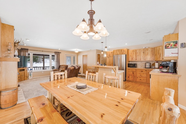 dining space featuring light hardwood / wood-style floors and a notable chandelier