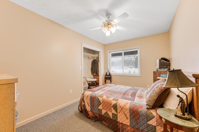 carpeted bedroom with ceiling fan, a textured ceiling, and a closet