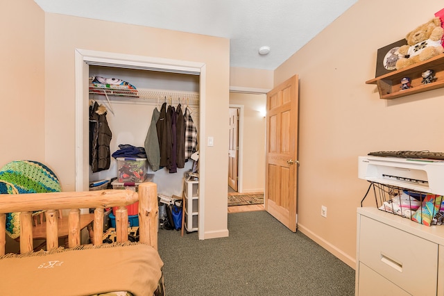 bedroom featuring dark colored carpet and a closet