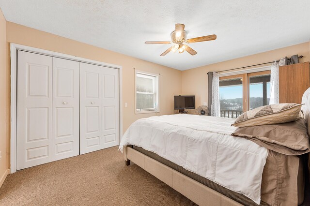 bedroom featuring carpet flooring, a textured ceiling, a closet, and ceiling fan