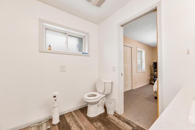 bathroom featuring wood-type flooring and toilet