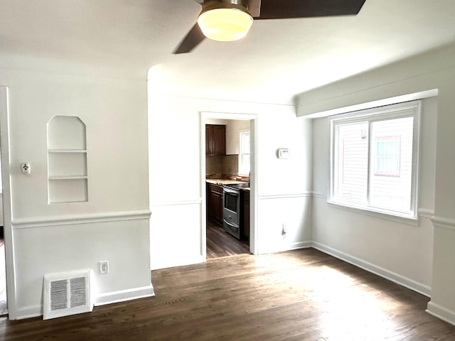 unfurnished living room with ceiling fan and dark wood-type flooring