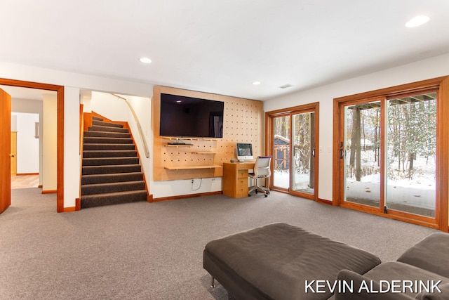 living room featuring carpet flooring, built in desk, and a healthy amount of sunlight