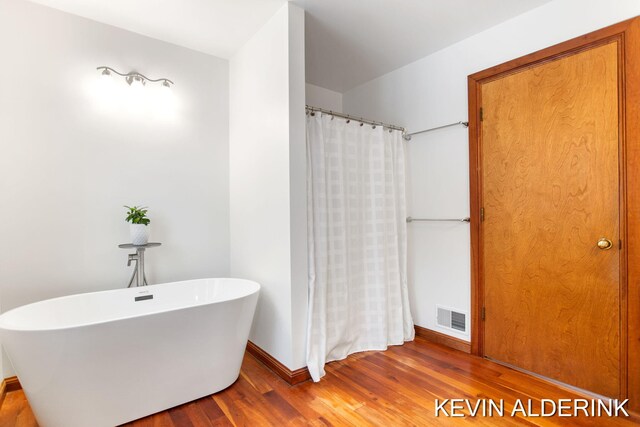 bathroom featuring hardwood / wood-style flooring and a tub