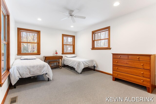 bedroom with carpet flooring, ceiling fan, and multiple windows