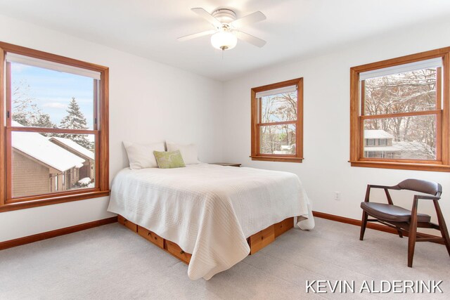 carpeted bedroom featuring multiple windows and ceiling fan