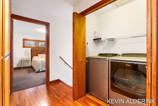 laundry area with separate washer and dryer and light wood-type flooring