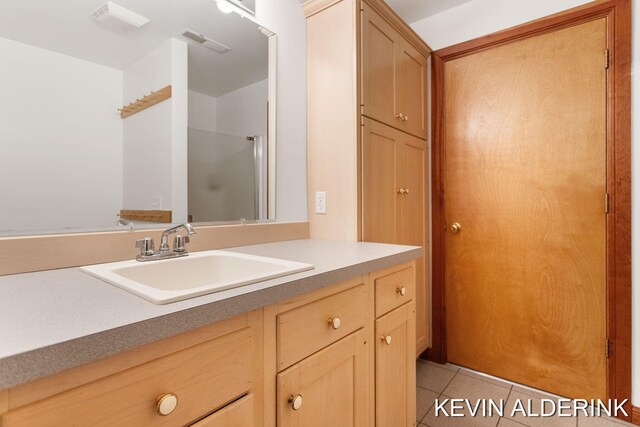 bathroom featuring tile patterned floors, vanity, and an enclosed shower