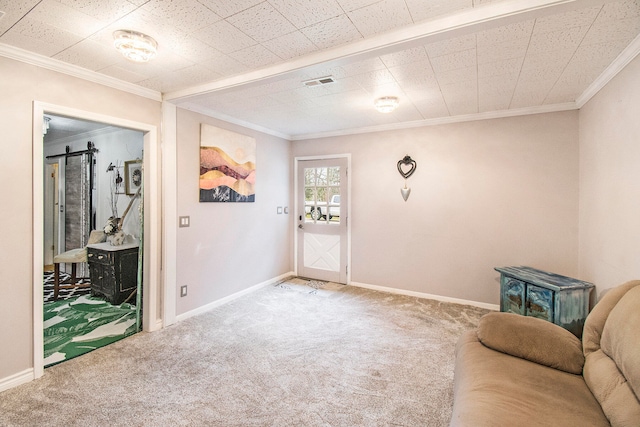 living area featuring a barn door, crown molding, and carpet floors