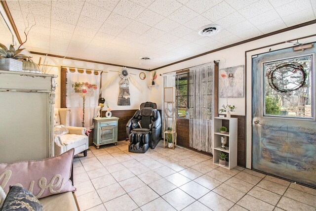 unfurnished room featuring crown molding, plenty of natural light, and light tile patterned flooring