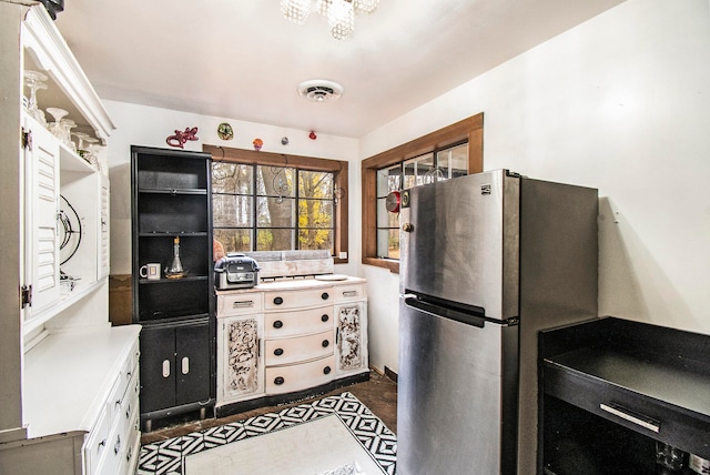 kitchen featuring white cabinets, dark hardwood / wood-style floors, and stainless steel fridge