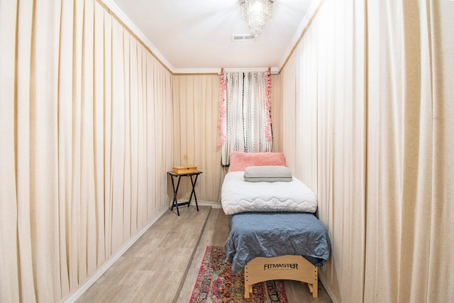 bedroom with light hardwood / wood-style floors and ornamental molding