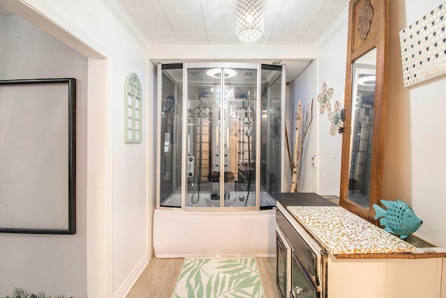 interior space featuring shower / bath combination with glass door, hardwood / wood-style floors, and ornamental molding