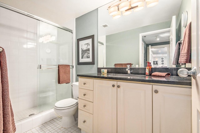 bathroom with tile patterned flooring, vanity, a shower with door, and toilet