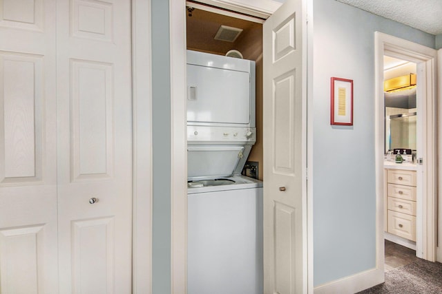 washroom with stacked washing maching and dryer