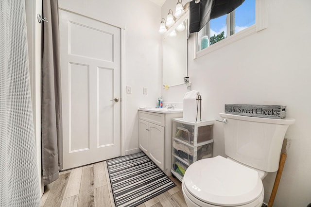 bathroom with vanity, hardwood / wood-style flooring, and toilet