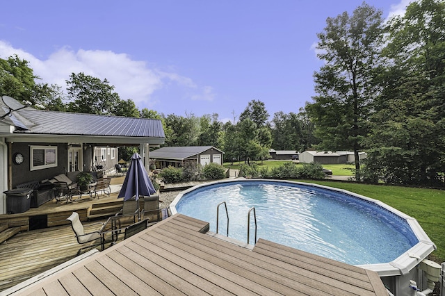 view of swimming pool featuring a wooden deck, an outbuilding, and a yard