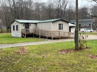 view of front of property featuring a deck and a front yard