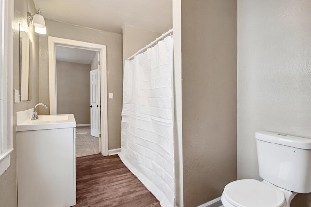 bathroom with toilet, vanity, and hardwood / wood-style flooring