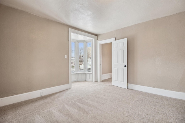 carpeted spare room featuring a textured ceiling