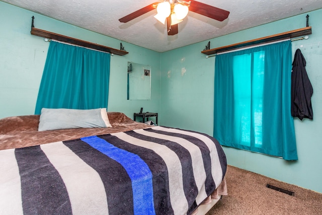 carpeted bedroom with a textured ceiling and ceiling fan