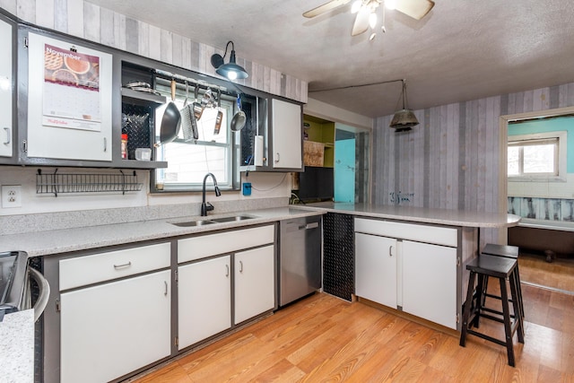 kitchen featuring a kitchen bar, plenty of natural light, white cabinets, and appliances with stainless steel finishes