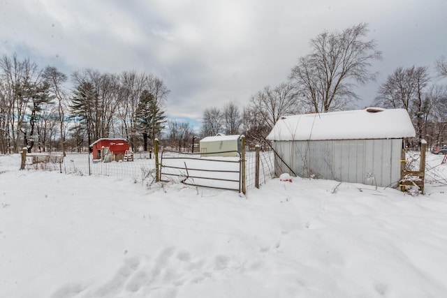 yard layered in snow with an outdoor structure