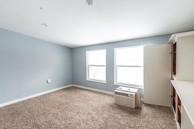 spare room with light colored carpet and an AC wall unit