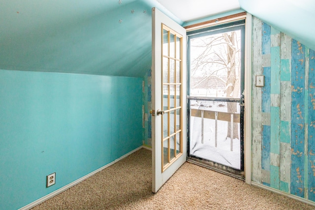 doorway to outside with carpet flooring and lofted ceiling