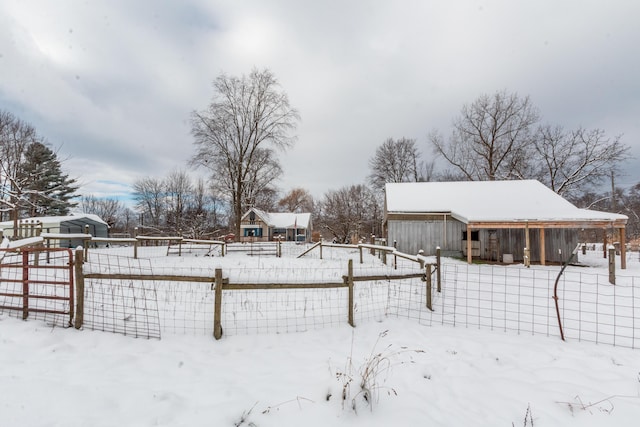 snowy yard featuring an outbuilding