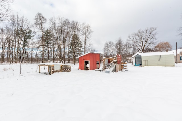 yard layered in snow featuring an outbuilding