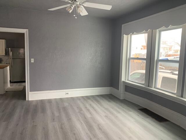 unfurnished room featuring ceiling fan and light wood-type flooring