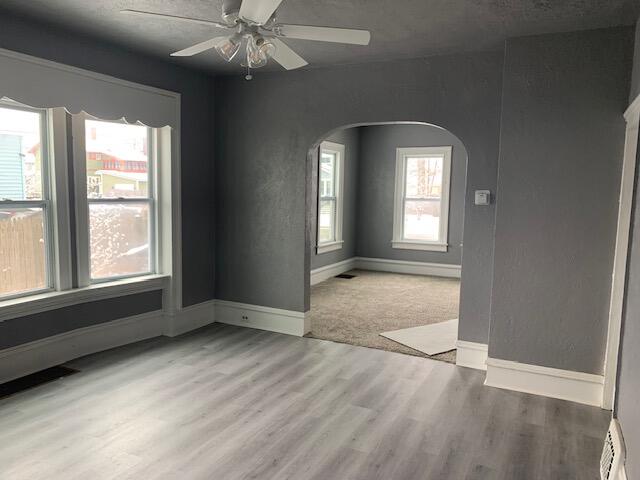 unfurnished room with ceiling fan, light hardwood / wood-style floors, and a baseboard radiator