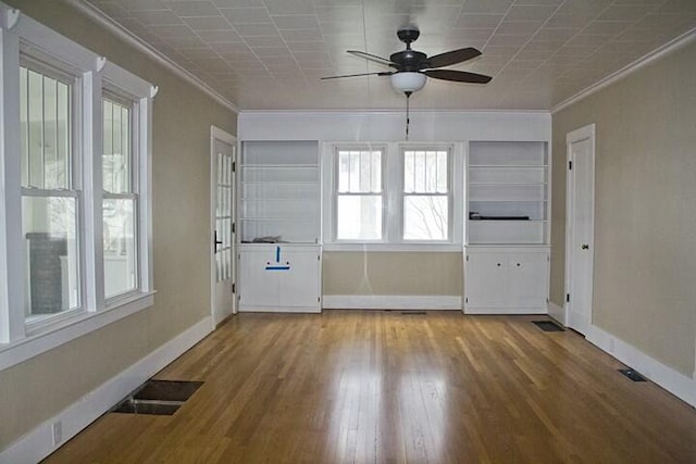 empty room featuring wood-type flooring, ornamental molding, and ceiling fan